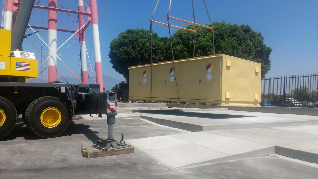 Offloading hazmat storage locker onto concrete pad via crane