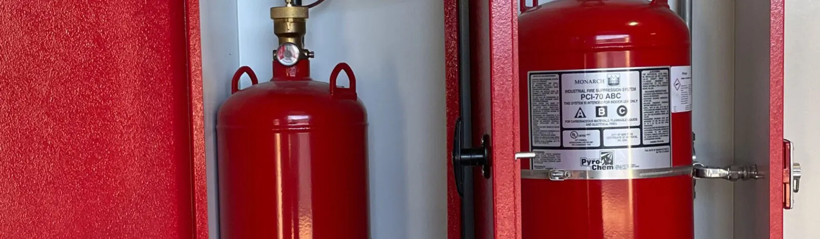 Dry-chemical fire suppression system inside a red chemical storage enclosure